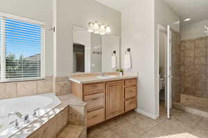 Full bath with vanity, a tub with jets, light tile patterned floors, and a walk in shower