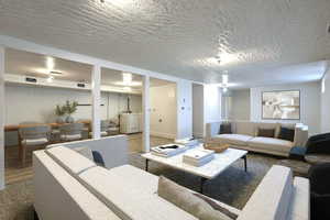 Living area with wood finished floors and a textured ceiling