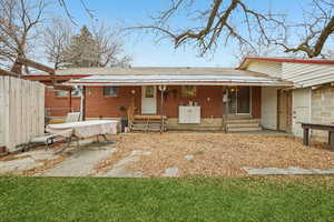 Back of house featuring brick siding, a shingled roof, and a porch