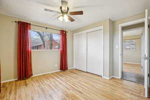 Unfurnished bedroom featuring light wood-type flooring, a closet, and ceiling fan