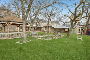 View of grassy yard featuring an outdoor structure, a patio, and a gazebo