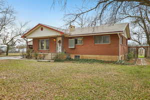 View of front of home featuring a front yard and brick siding