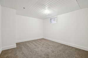 Carpeted empty room featuring baseboards