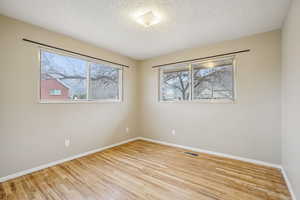 Unfurnished room featuring light wood-style flooring and a textured ceiling