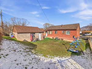 Rear view of property with view of detached garage
