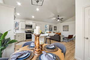 Dining room with lofted ceiling, light wood-style flooring, recessed lighting, and ceiling fan