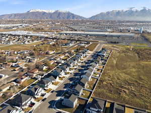 Aerial view of property and surrounding area with mountains and nearby suburban area