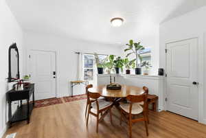 Dining area with light wood finished floors and a textured ceiling