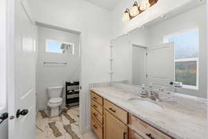 Bathroom featuring vanity and light marble finish flooring