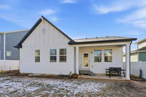 Snow covered property featuring board and batten siding, a patio area, and entry steps
