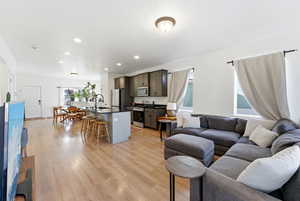 Living room with light wood finished floors and recessed lighting
