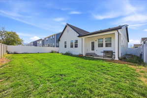 Expansive green lawn with a white vinyl privacy fence