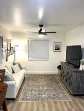 Living room with light wood-style floors and a ceiling fan