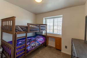Bedroom featuring dark colored carpet and a textured ceiling