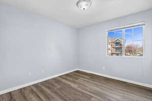 Empty room featuring wood finished floors and a textured ceiling