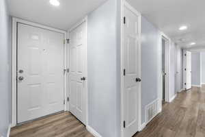 Corridor featuring light wood finished floors and recessed lighting