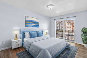 Bedroom featuring a textured ceiling, wood finished floors, and access to outside