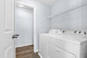 Washroom with washer and dryer and dark wood-style floors