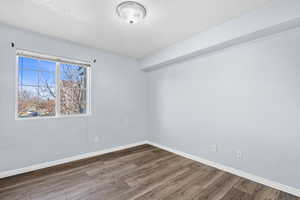 Empty room with a textured ceiling and wood finished floors