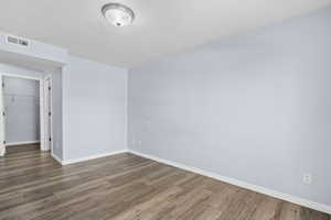 Empty room with a textured ceiling and wood finished floors