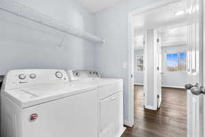 Laundry area featuring a textured ceiling, dark wood-type flooring, and washer and clothes dryer