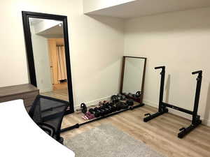 Workout room with light wood-style floors and baseboards