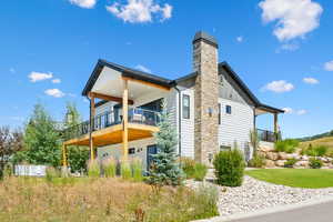 View of side of home with board and batten siding, a deck, and a chimney