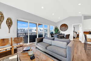 Living room featuring vaulted ceiling, light wood-style floors, and recessed lighting