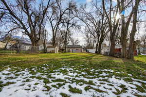 Yard covered in snow with a residential view and a storage unit