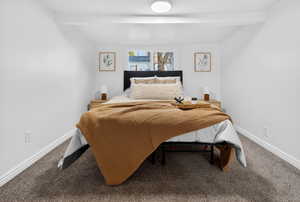 Carpeted bedroom with beam ceiling