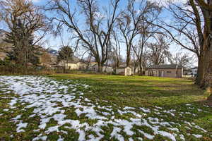 Snowy yard featuring a storage shed
