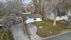 View of front of property featuring a front yard and view of wooded area