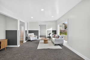 Carpeted living room with recessed lighting and baseboards