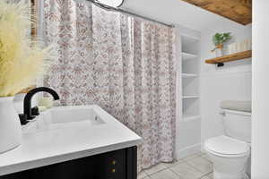 Full bath with vanity, a shower with curtain, built in features, and light tile patterned floors