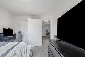 Bedroom featuring an office area and light colored carpet