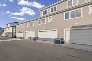 Rear view of property featuring stucco siding and a garage