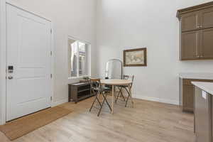 Dining area featuring a high ceiling and light wood finished floors