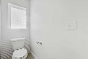 Half bath with toilet and tile patterned floors