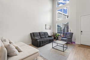 Living room with wood finished floors and a high ceiling