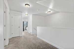 Hallway with an upstairs landing and light carpet