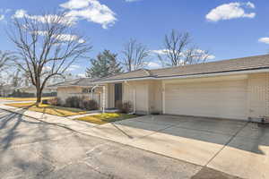 Single story home with brick siding, driveway, and a garage