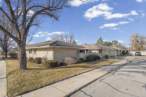 View of front of house featuring concrete driveway, brick siding, a front yard, and a garage