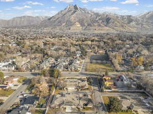 Aerial view of property and surrounding area featuring nearby suburban area and a mountainous background