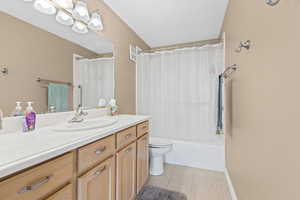 Bathroom featuring vanity, light tile patterned floors, and shower / tub combo with curtain