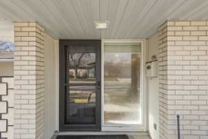 Entrance to property featuring brick siding