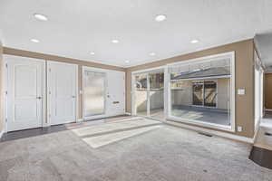 Unfurnished room featuring a textured ceiling, crown molding, recessed lighting, and carpet flooring