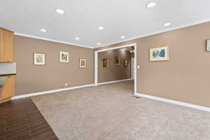 Unfurnished living room with ceiling fan, wood finish floors, a textured ceiling, recessed lighting, and crown molding
