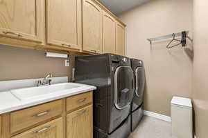 Laundry room with independent washer and dryer, cabinet space, and light tile patterned flooring