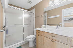 Full bath with light tile patterned flooring, a stall shower, and vanity