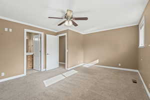 Unfurnished bedroom featuring ornamental molding, light colored carpet, ceiling fan, and connected bathroom